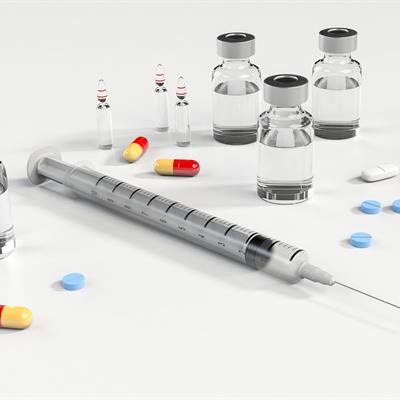 A selection of medication delivery methods including a syringe, pills and liquid