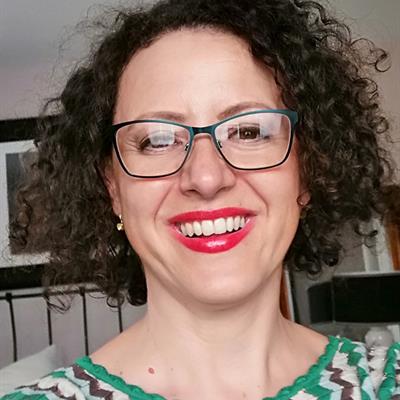 Smiling woman with curly hair and wearing glasses