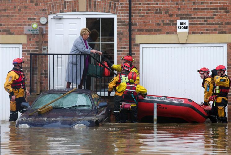 A rescue team help a lady stranded by a flood. Credit: UK Climate Resilience